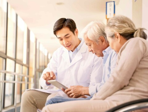 Asian senior couple in wheelchair consulting an asian male doctor